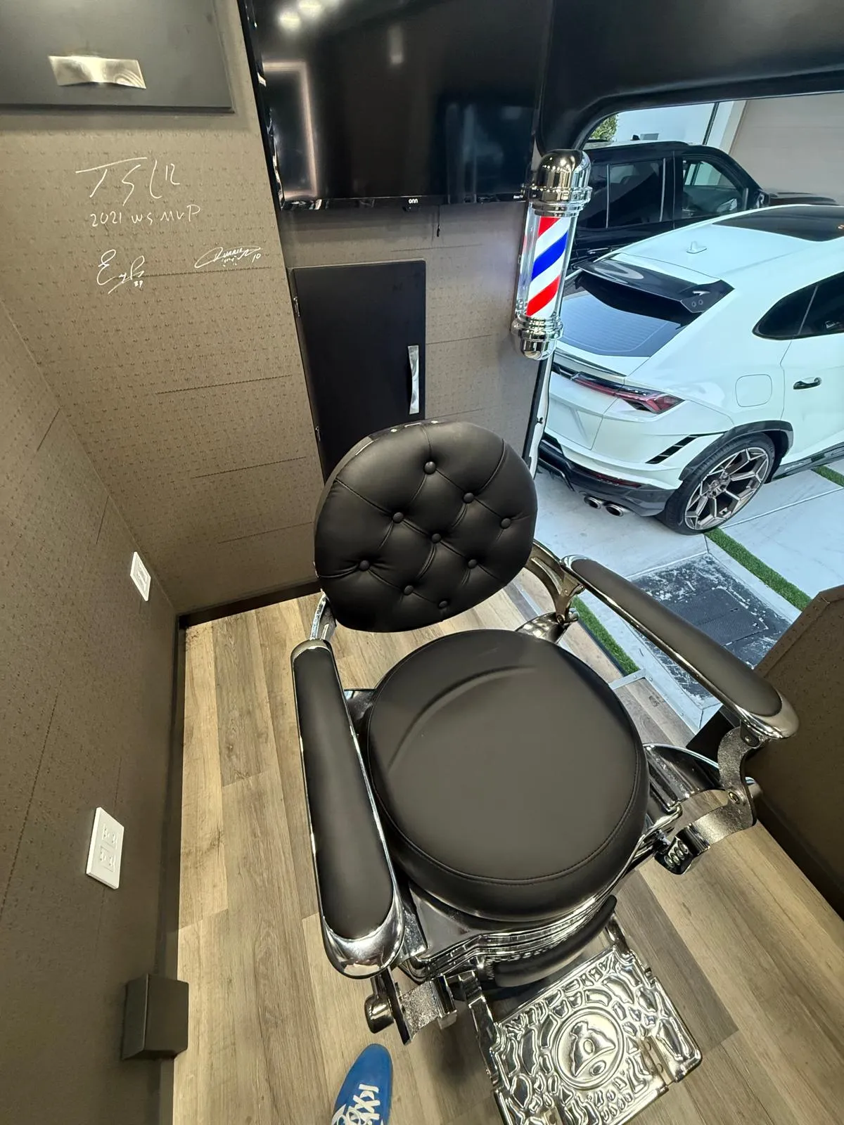 Interior de la van: la silla de barbero y la pared firmada por los clientes