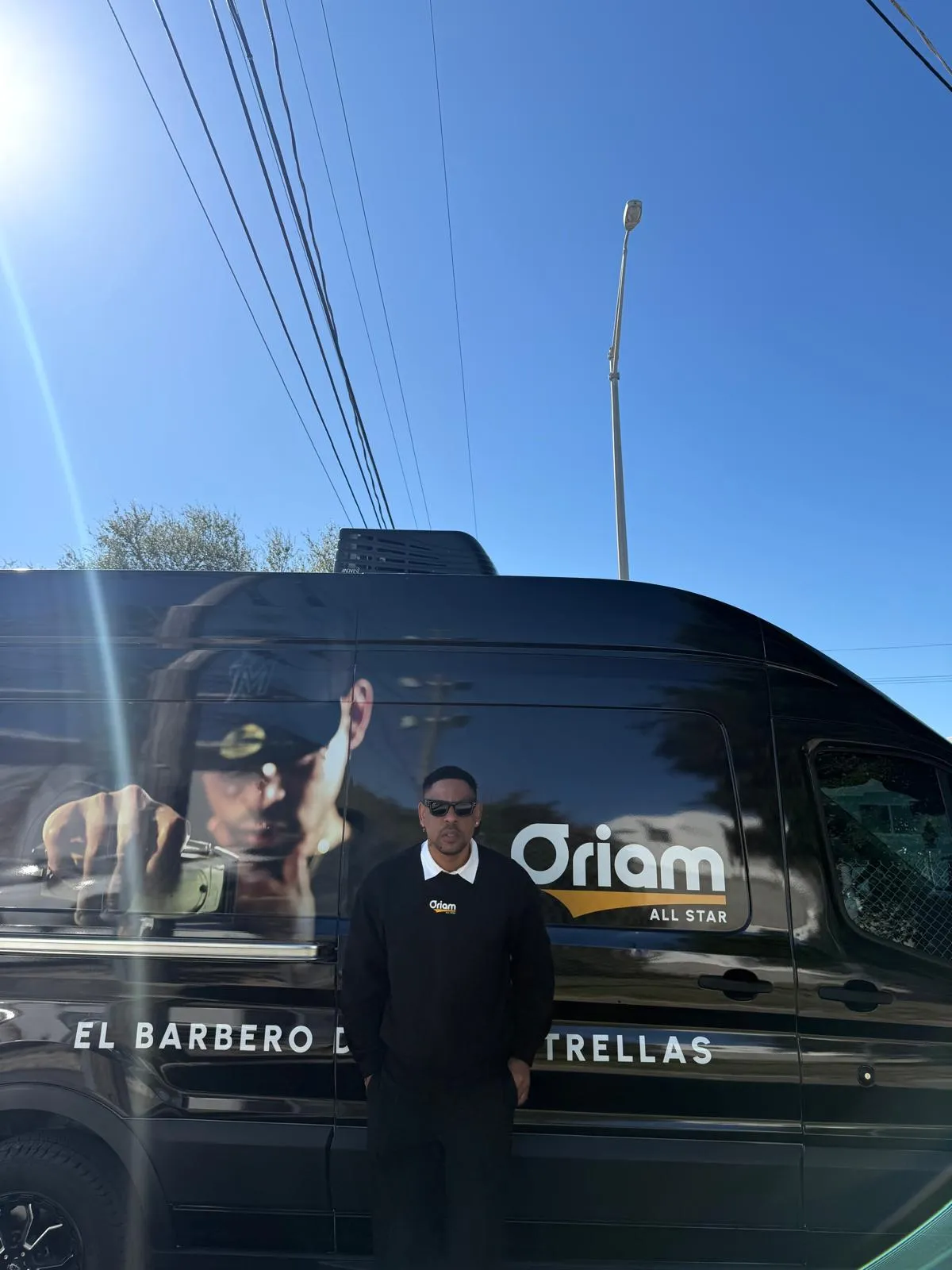 Oriam delante de la van rotulada, listo para salir a una visita